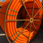 Reeled HDPE conduit pipe for underground electrical and fiber optic installation.