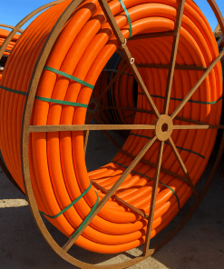 Reeled HDPE conduit pipe for underground electrical and fiber optic installation.